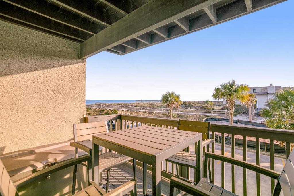 a patio with a table and chairs on a balcony at Sand Dollar Villas 109 in Fernandina Beach