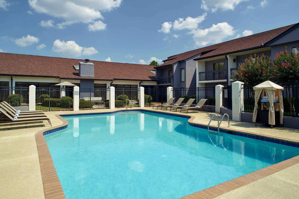 Una gran piscina con sillas y un edificio. en Sonesta Select Atlanta Norcross I 85, en Norcross