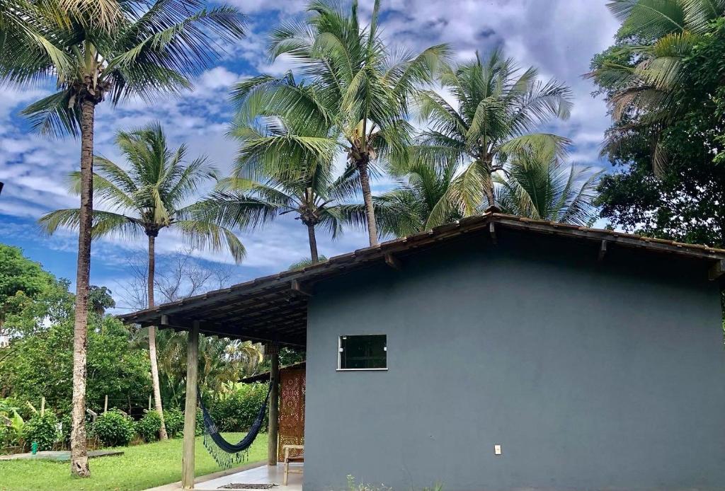 ein blaues Gebäude mit Palmen im Hintergrund in der Unterkunft Portal Mágico in Itacaré
