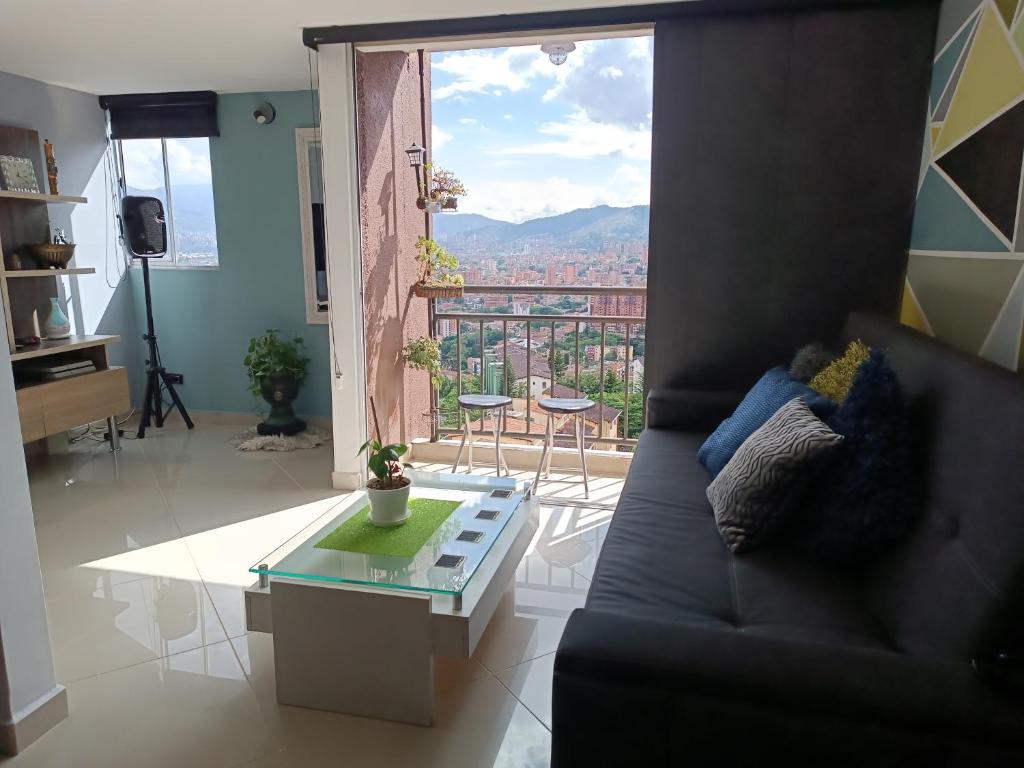 a living room with a couch and a glass table at Apartamento con vistas a la ciudad (Penthouse) cerca al Estadio, al Boulevard de la 70 y la Avenida 80 (Casinos, restaurantes, malls y otros). in Medellín