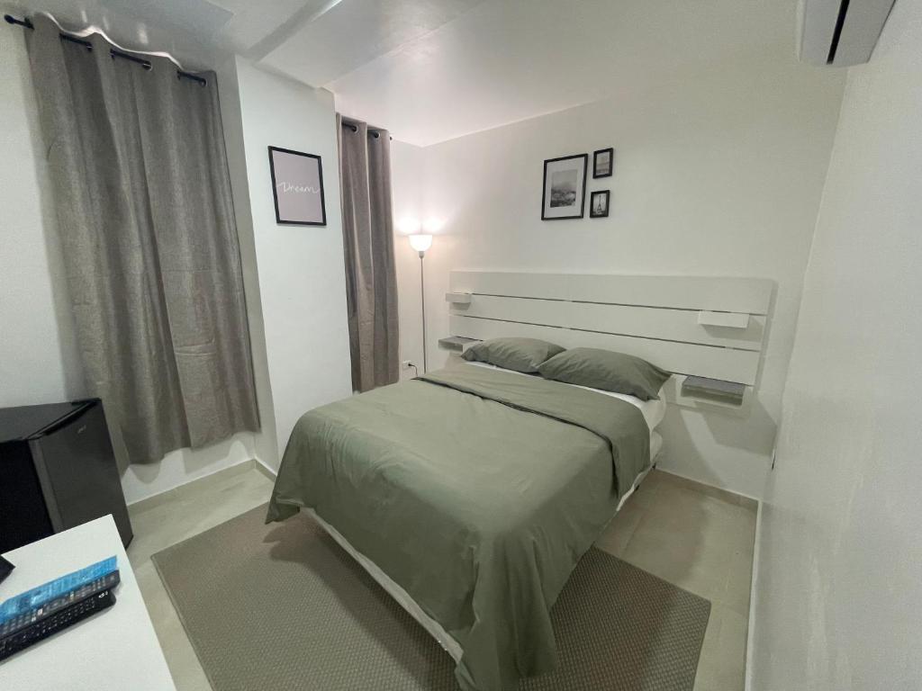 Hotel Conquistador Santo Domingo في سانتو دومينغو: غرفة نوم بيضاء بها سرير ونافذة