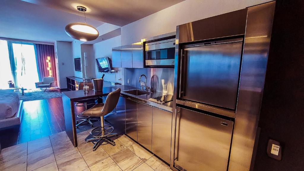 a kitchen with a stainless steel refrigerator and a desk at Luxury 53rd Flr Condo with Amazing Sunset View & Balcony NO ReFee at Palms Place in Las Vegas