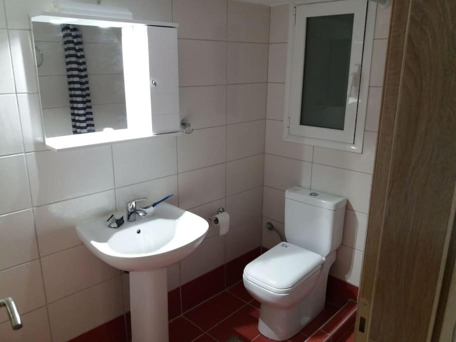 a bathroom with a sink and a toilet and a mirror at Piraeus historical center in Piraeus