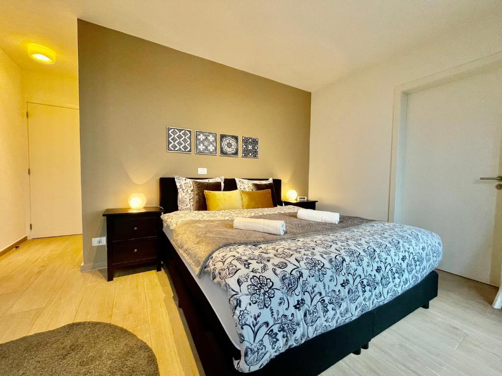 una camera con un letto con copriletto blu e bianco di OneLuxStay near Diamond District ad Anversa