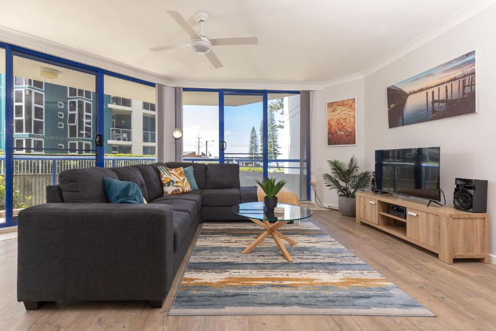 a living room with a couch and a tv at Heritage 103 in Tuncurry