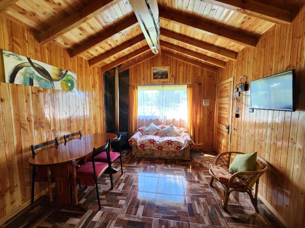 ein Esszimmer mit einem Tisch und einem Bett in einem Zimmer in der Unterkunft Cabaña Nuevo Amanecer in San José de la Mariquina