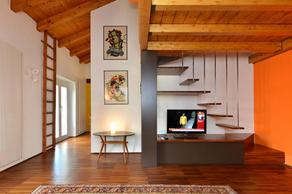 sala de estar con escalera y TV en Heart Milan Apartments Navigli, en Milán