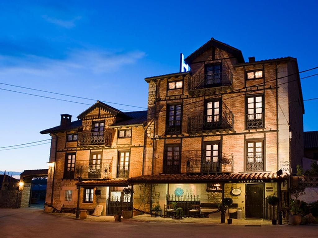 un gran edificio de ladrillo con ventanas en una calle en Posada Santa Ana, en Suances