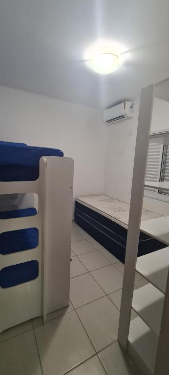 Habitación pequeña con cama y escritorio. en Condomínio Canto Verde en Ubatuba