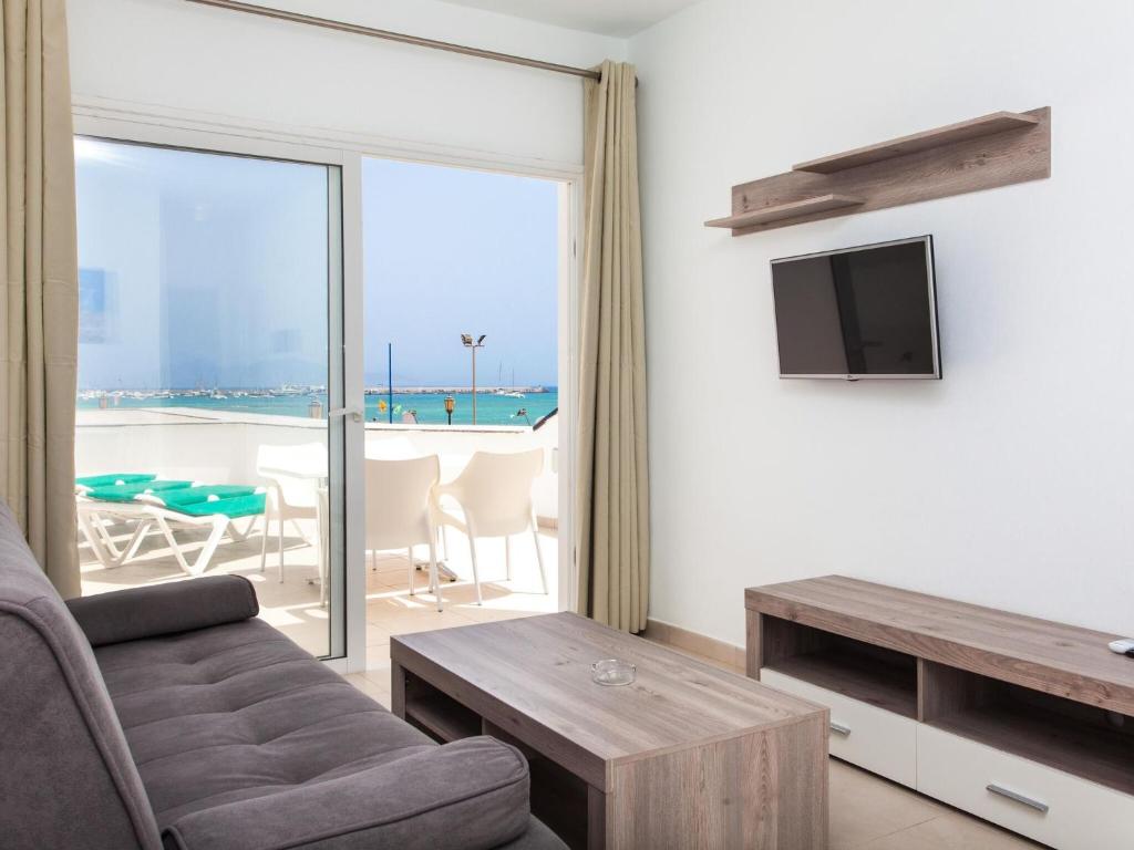 科拉雷侯的住宿－Resort, Corralejo，带沙发和电视的客厅以及阳台。