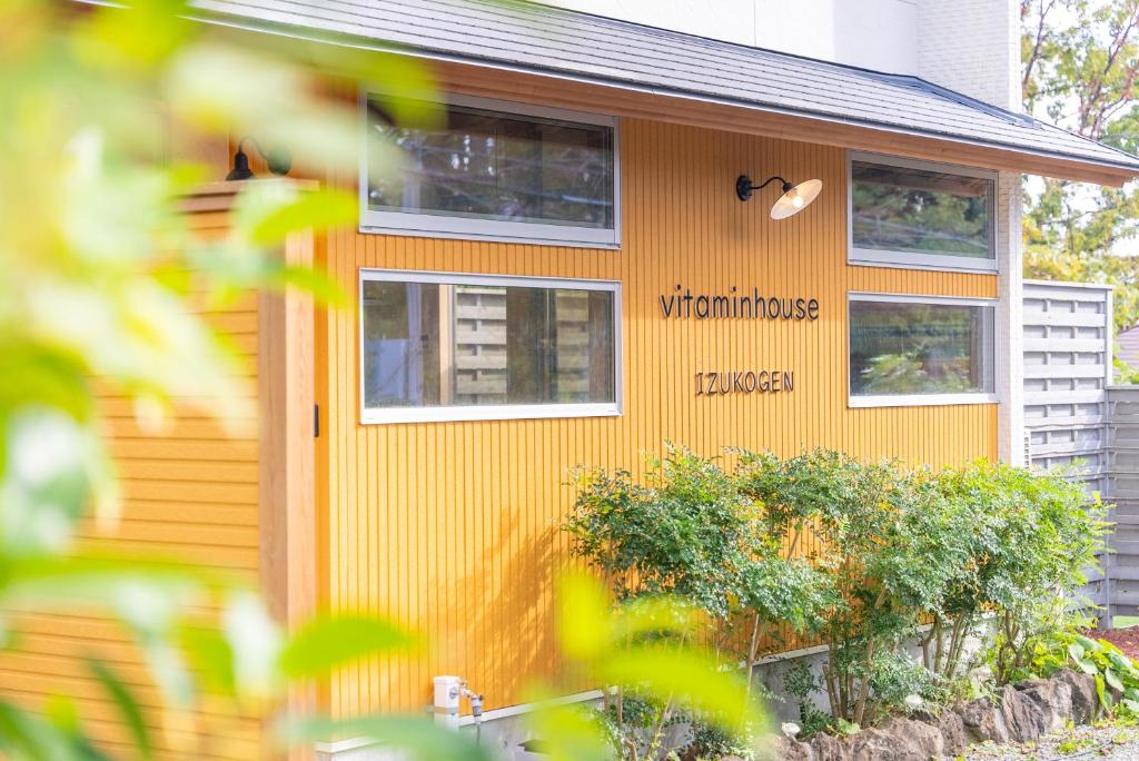 een huis met een bord erop bij ビタミンハウス伊豆高原 - vitaminhouse IZUKOGEN in Ito