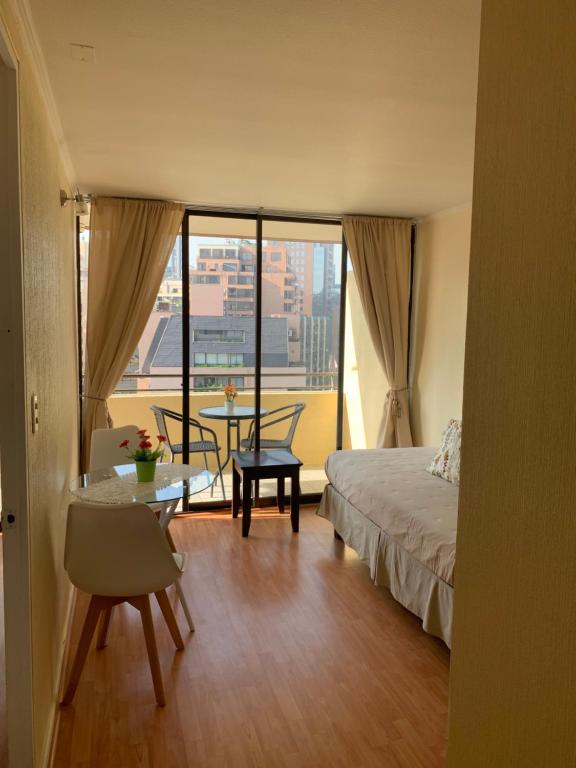 1 dormitorio con cama y mesa con vistas en CentriK Location Apartments Encomenderos 200, en Santiago