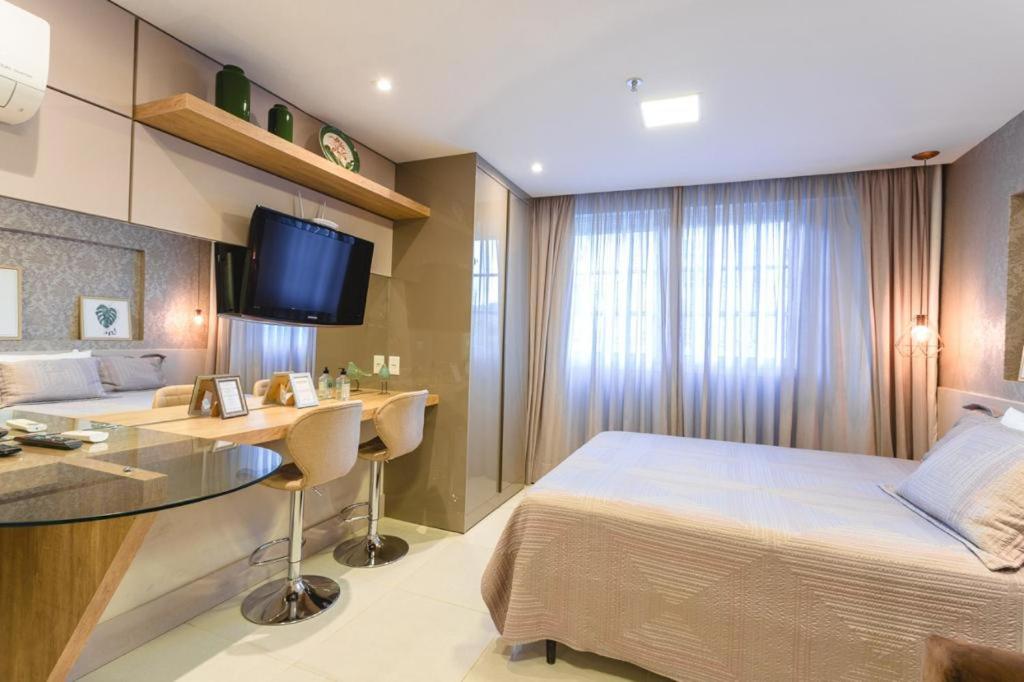 sypialnia z łóżkiem, biurkiem i telewizorem w obiekcie Apart Mangabeiras Granja Brasil Itaipava w mieście Itaipava