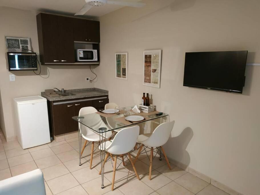 cocina con mesa de cristal y sillas blancas en Departamento en Córdoba, Villa Belgrano en Córdoba