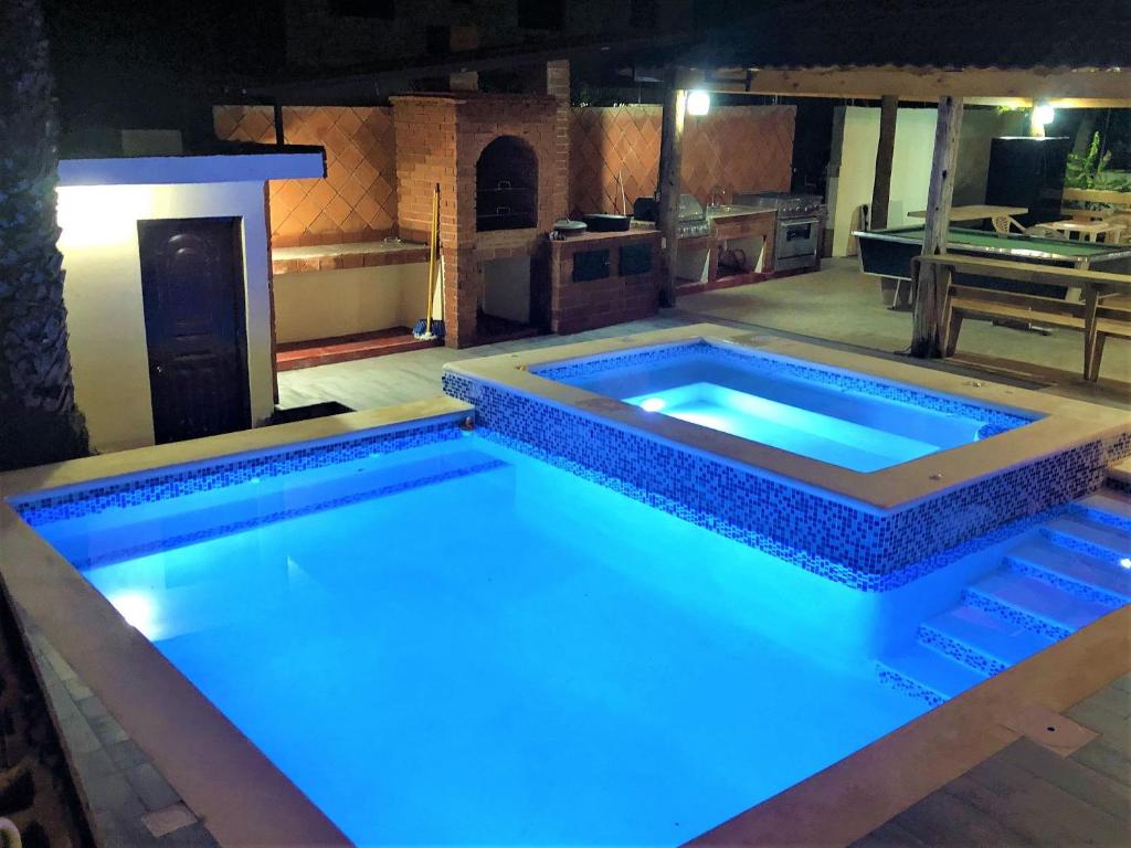 a swimming pool with blue lights in a kitchen at Villa Mi Patio By Hospedify - Hermosa villa con mesa de billar y río cristalino a 3 min Un pequeño paraíso en Jarabacoa in Jarabacoa