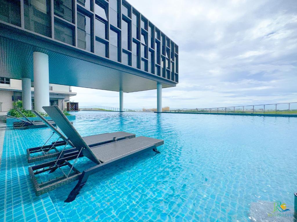 a swimming pool with a chair in the middle of a building at Bali Sea View Residences Melaka at Stayrene in Melaka