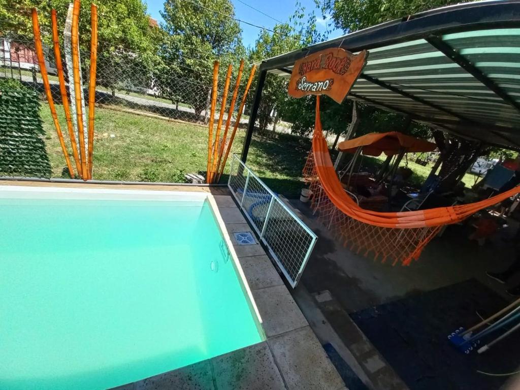 an empty swimming pool with a hammock and an umbrella at HARD ROCK SERRANO in Santa María