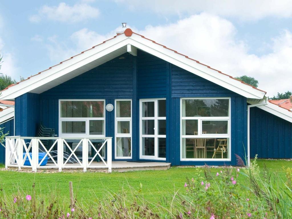 a blue cottage with large windows at 6 person holiday home in Otterndorf in Otterndorf