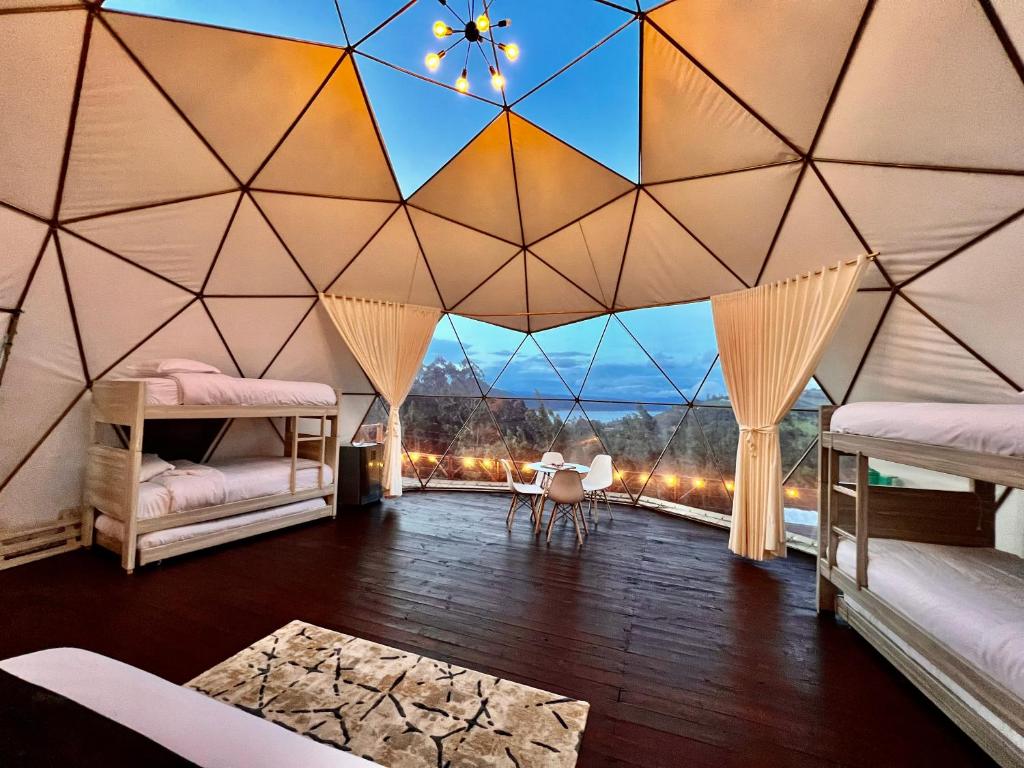 Cette chambre dispose de lits et d'un plafond avec vue. dans l'établissement Golden Glamping, à Guatavita
