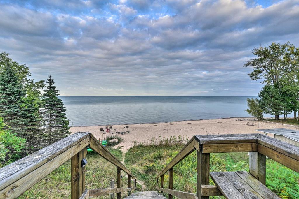 a wooden staircase leading to a beach with a view at Lakefront Forestville Paradise with Private Beach! 