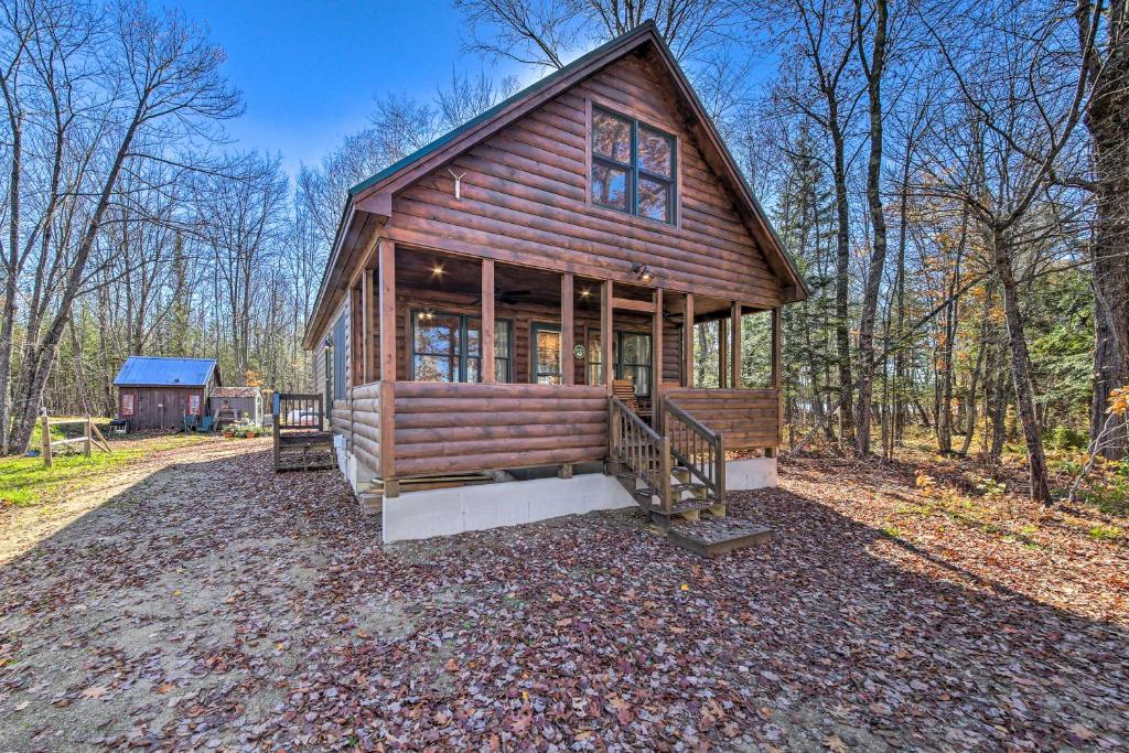 a large wooden cabin in the woods with a porch at Inviting Webb Lake Cabin with Mountain Views 