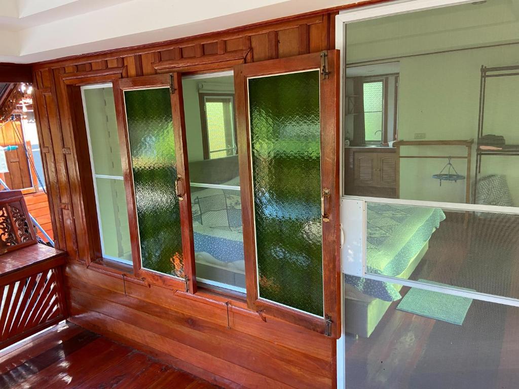 a group of glass windows in a room at Lampang Hideaway Guesthouse in Lampang