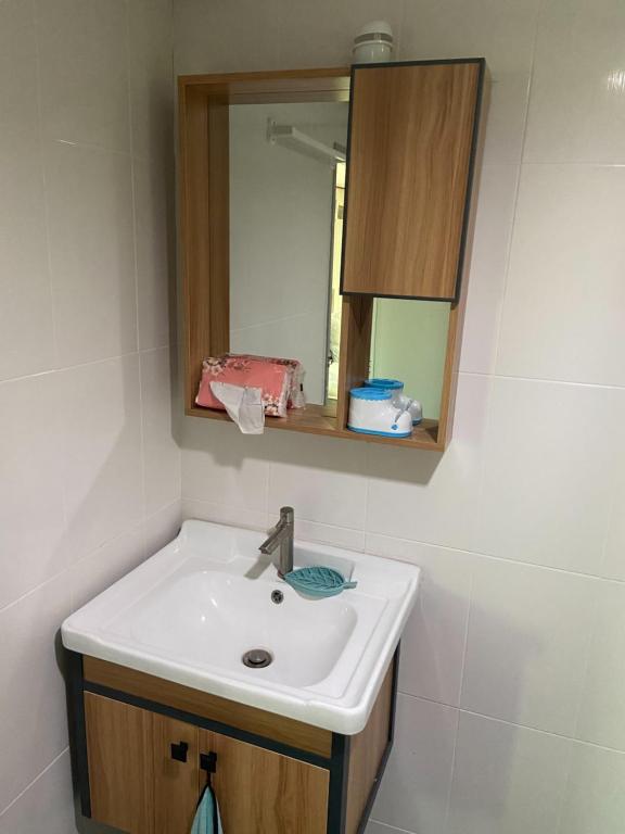 a bathroom with a sink and a mirror at Lampang Hideaway Guesthouse in Lampang