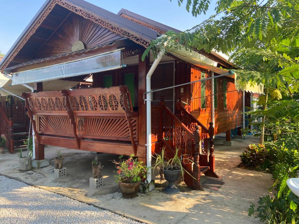 a building with pots of plants in front of it at Lampang Hideaway Guesthouse in Lampang
