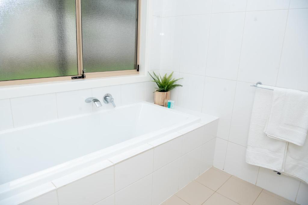 un bagno bianco con lavandino e finestra di Triple Creek Guest House - Barossa Region a Seppeltsfield