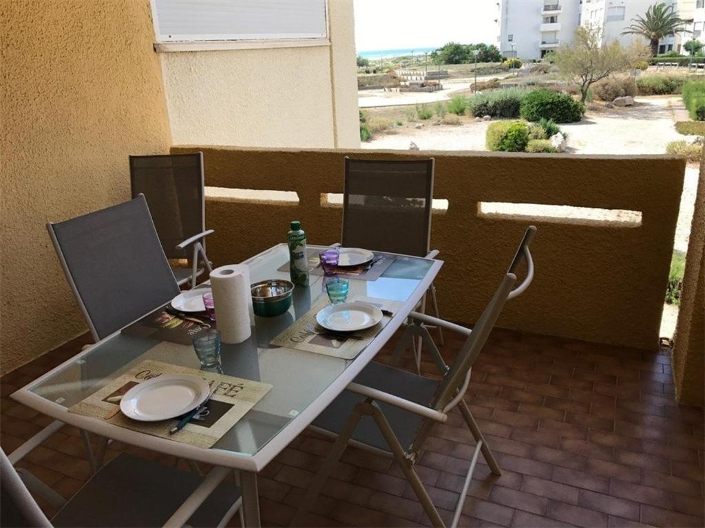uma mesa com cadeiras e pratos numa varanda em Appartement Port Leucate, 2 pièces, 5 personnes - FR-1-81-49 em Port Leucate