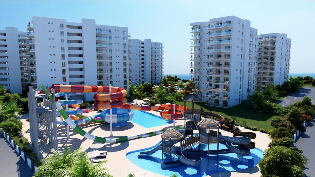 an aerial view of a water park with a water slide at Gloria Apartments in Caesar Blue Resort,Gym, Swimming Pools, Sauna, Hammam, Kids' club available in Perivolia tou Trikomou
