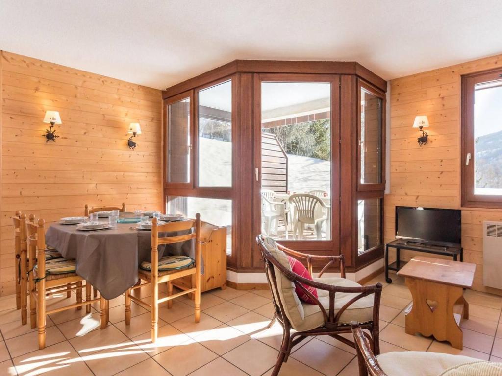 a dining room with a table and chairs and a television at Spacieux appartement à Serre-Chevalier pour 6 pers. avec terrasse, parking couvert et wifi - FR-1-330E-74 in Le Villard-Late