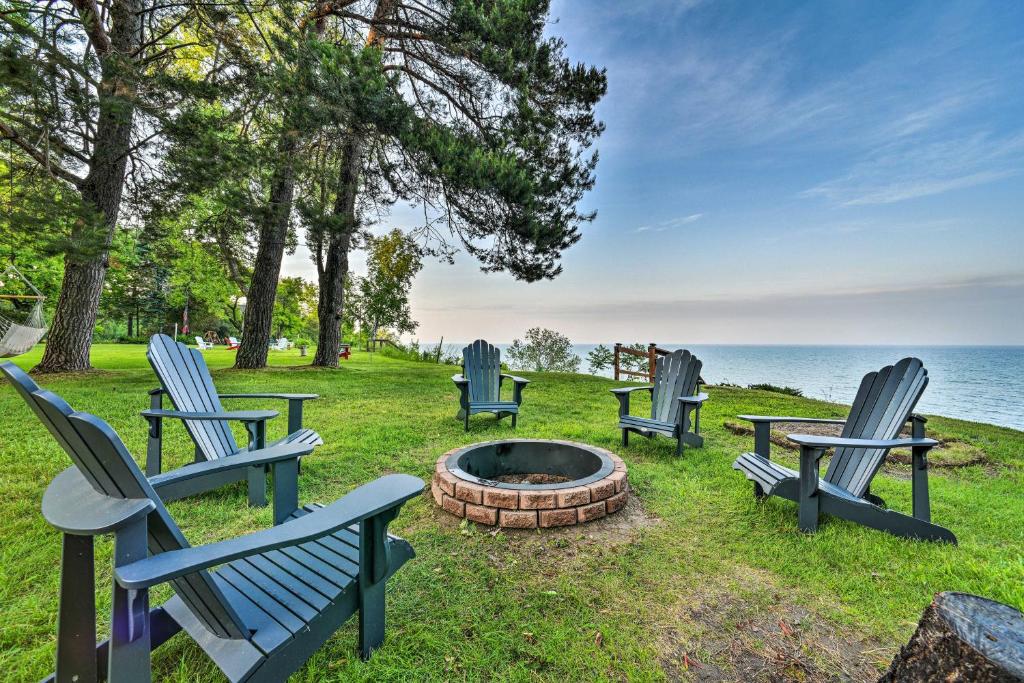 un grupo de sillas azules sentadas alrededor de una hoguera en Waterfront Lake Huron Getaway Private Beach!, en Forestville