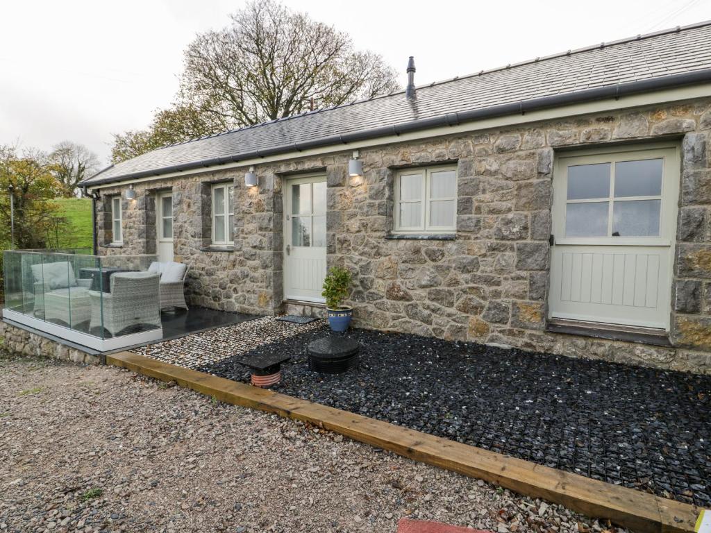 a stone house with a patio in front of it at Bryn Goleu in Llandudno