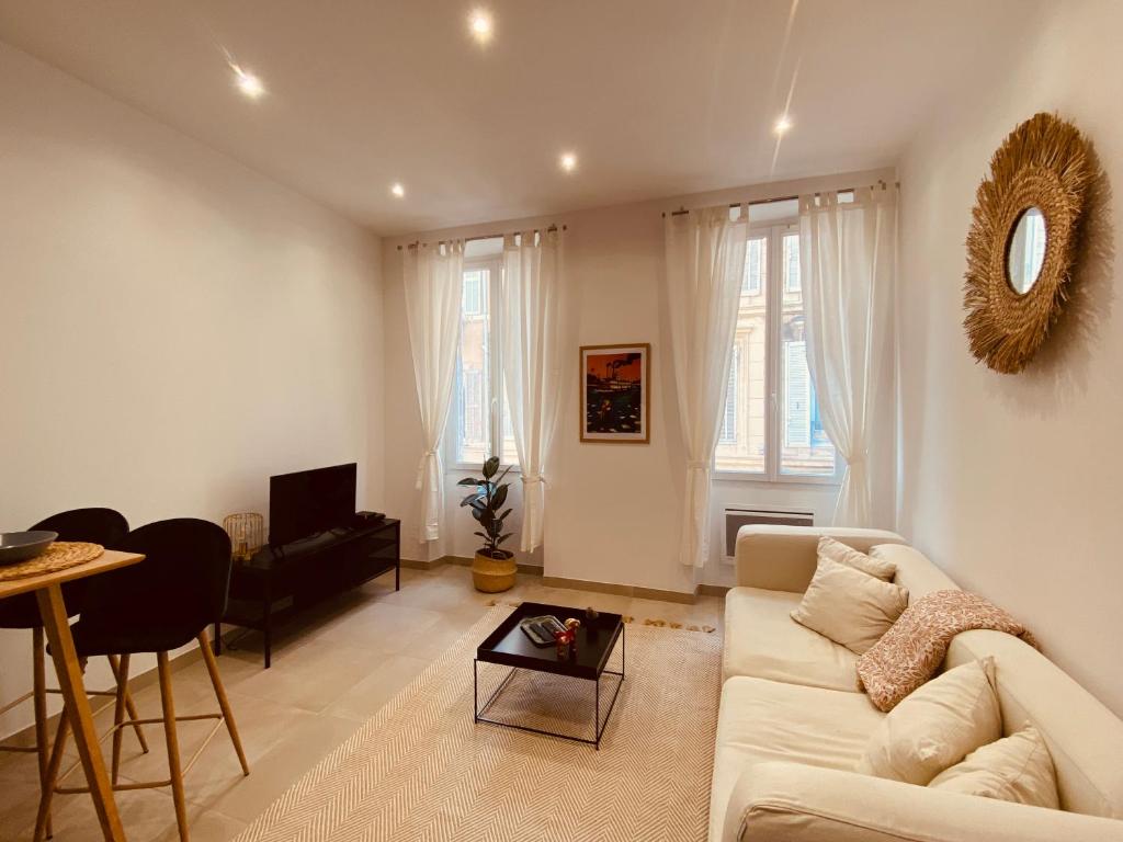ein Wohnzimmer mit einem Sofa und einem Tisch in der Unterkunft Au cœur de Marseille : superbe appartement ! in Marseille