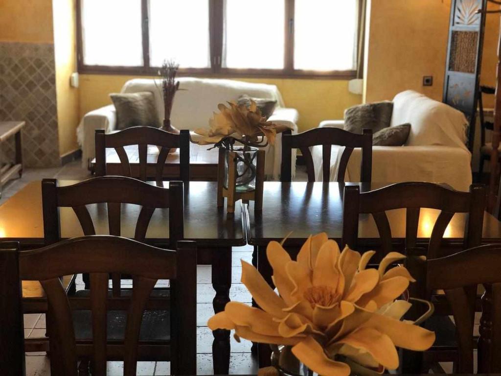 un soggiorno con tavolo, sedie e un fiore di Casa rural hormilla a Hormilla