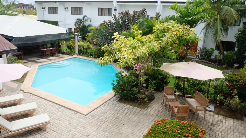 uma vista superior para uma piscina com cadeiras e guarda-sóis em Red Knight Gardens em Davao