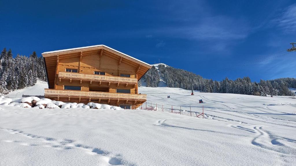 una cabina in legno su una pista sciistica nella neve di Bauernhof Streitenau a Hopfgarten im Brixental