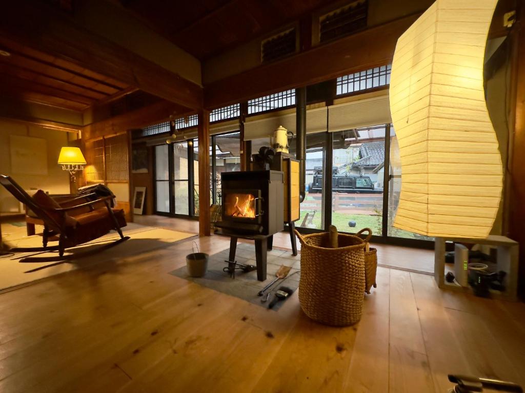 a living room with a fireplace and a piano at 犬と泊まれる平屋Dog friendly house 黄昏 in Misaki
