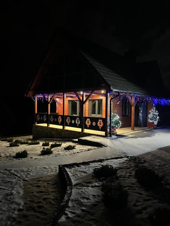 a house decorated with christmas lights at night at Chata na Czarnym Groniu in Korbielów