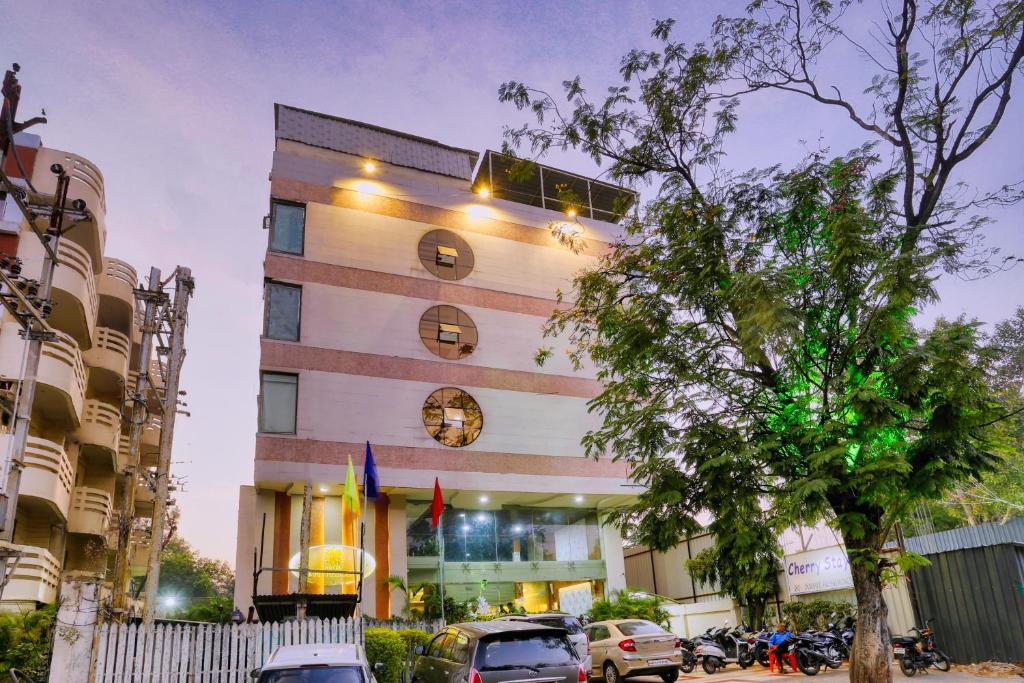 a building with cars parked in front of it at Hotel Amrit Residency in Indore