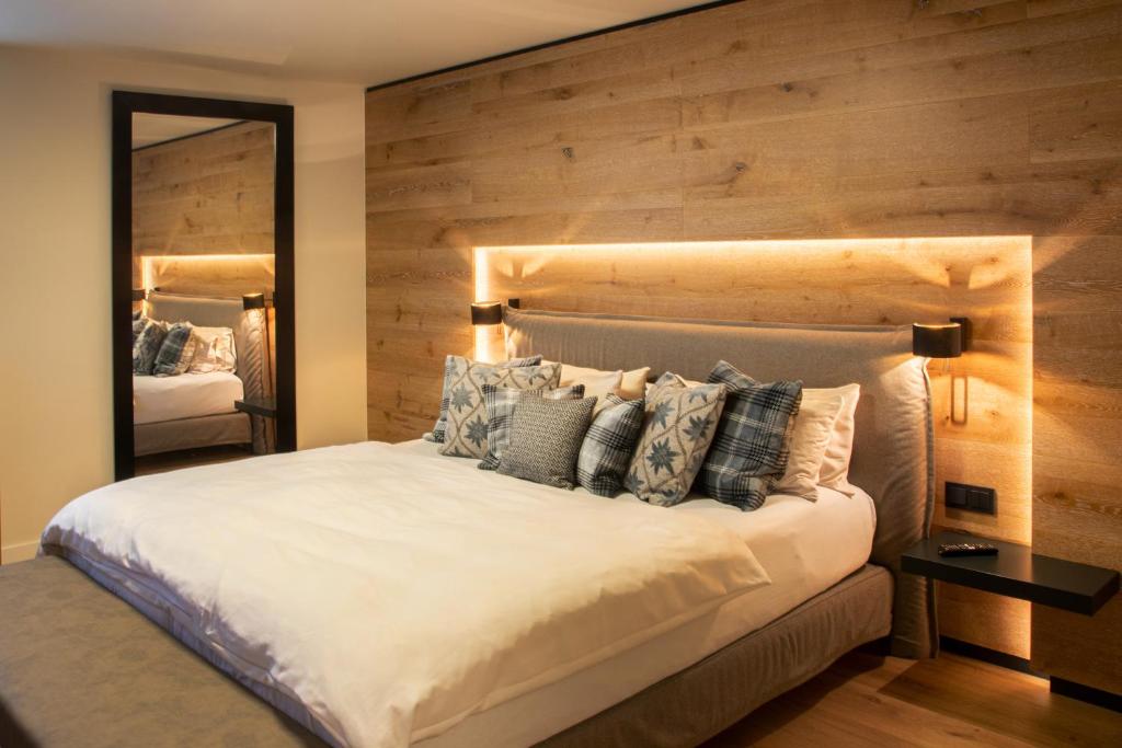 a bedroom with a large bed with a wooden wall at Weber Hofmark Apartments in Bad Birnbach