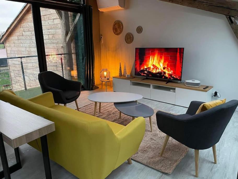 a living room with a fireplace and a yellow couch and chairs at Maison esprit loft 