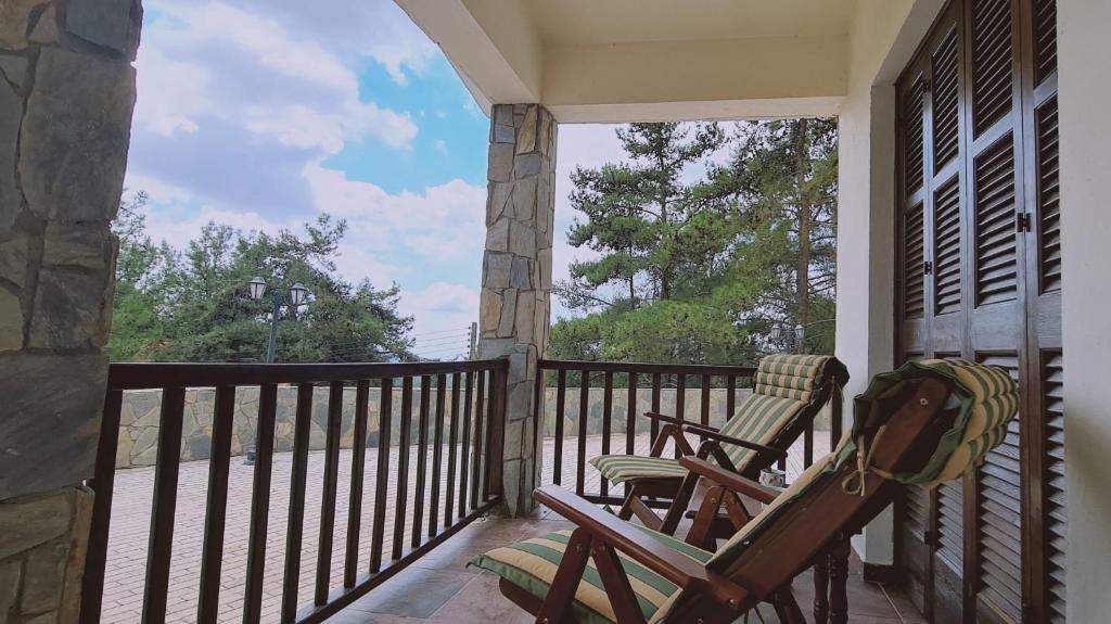 a porch with two rocking chairs on a balcony at STAY Forest View Villa in Platres