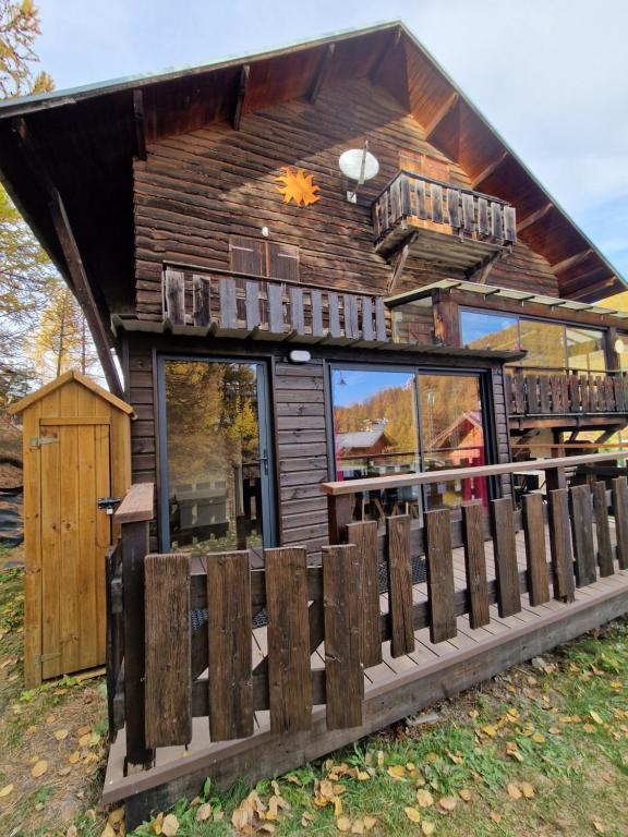 a log cabin with a fence in front of it at Boost Your Immo Vars Ô Chalet Dana 801 in Vars