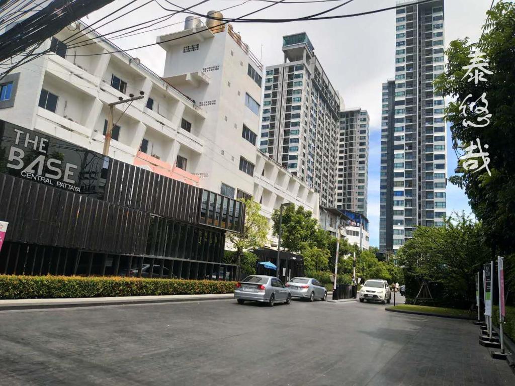 uma rua com carros estacionados ao lado de um edifício em The Base Central Pattaya Thai em Pattaya Central