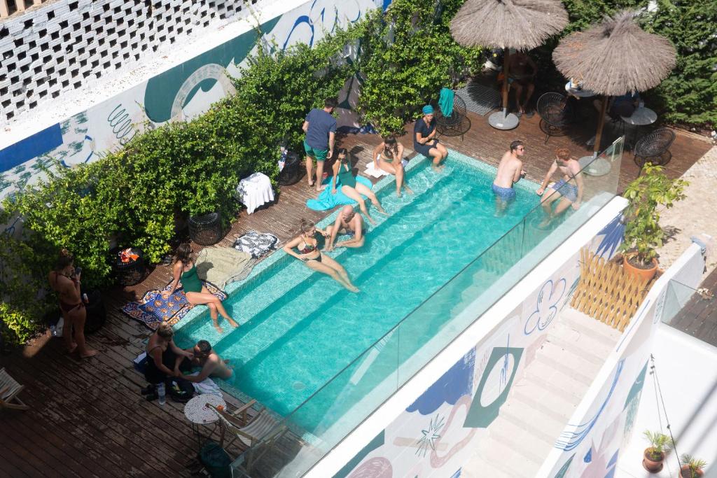 eine Gruppe von Personen, die in einem Schwimmbad schwimmen in der Unterkunft Selina Secret Garden Lisbon in Lissabon