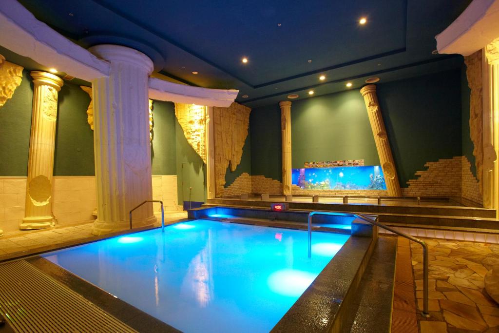 a large swimming pool in a room with columns at Spa World HOTEL&RESORT in Osaka