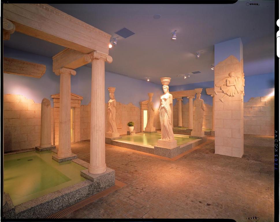 a museum with a statue in a room with columns at Spa World HOTEL&RESORT in Osaka