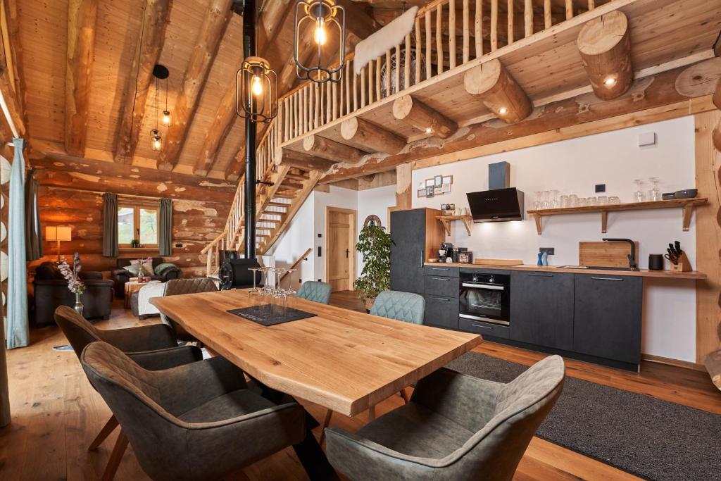 a dining room with a wooden table and chairs at Jakob Chalets in Perasdorf